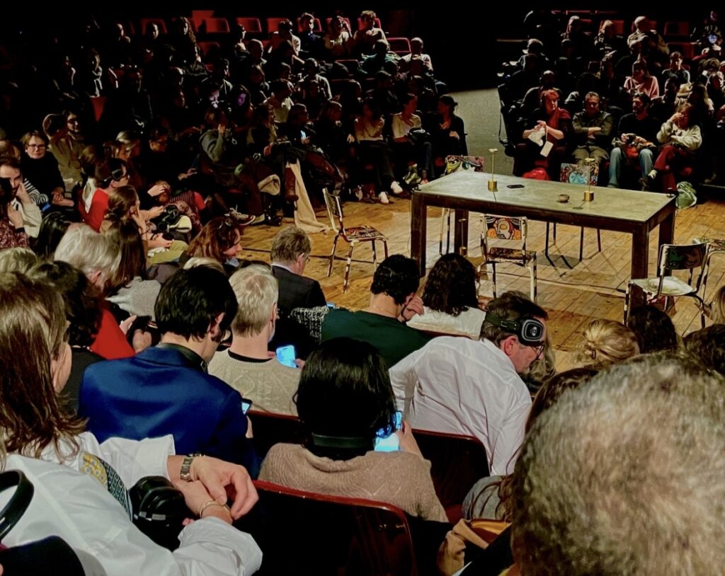 Spectateurs assis dans la salle circulaire du théâtre portant des casques Silent Disco France, prêts pour le spectacle immersif LA TABLE