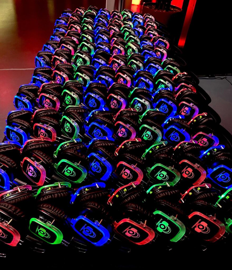 Rangées de casques silent disco lumineux Silent Disco France prêts à être distribués aux invités
