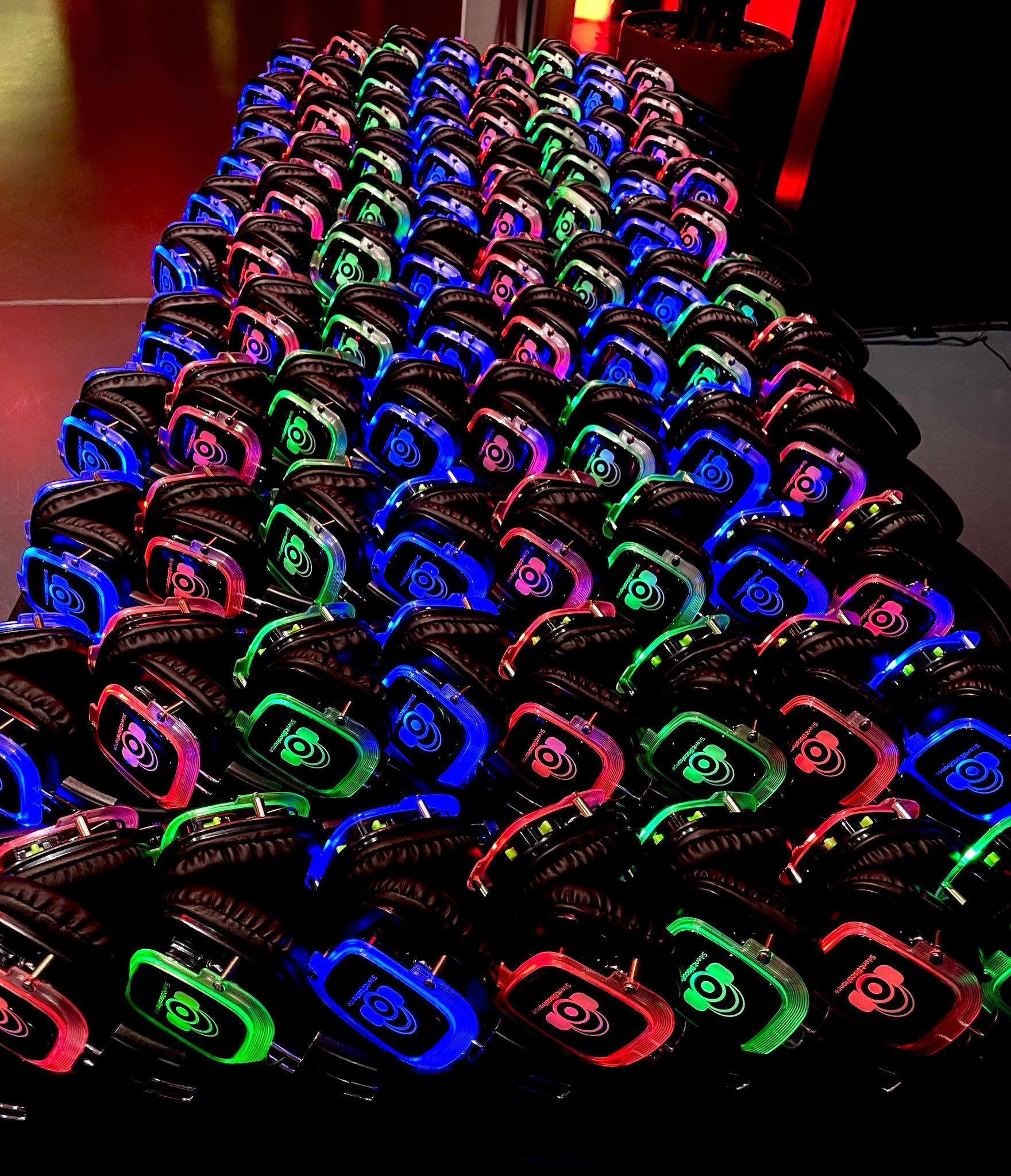 Rangées de casques silent disco lumineux Silent Disco France prêts à être distribués aux invités